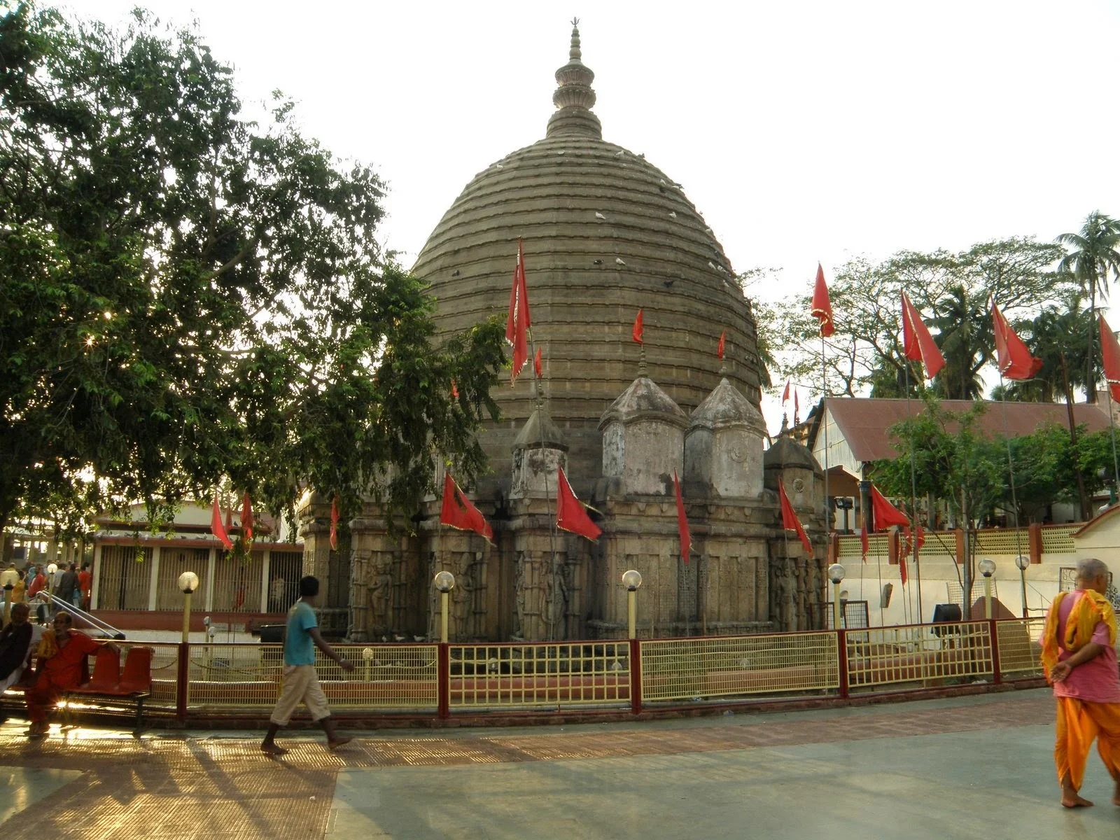 Đền Kamakhya cổ kính nhìn từ sân đền với hàng cây và khách hành hương