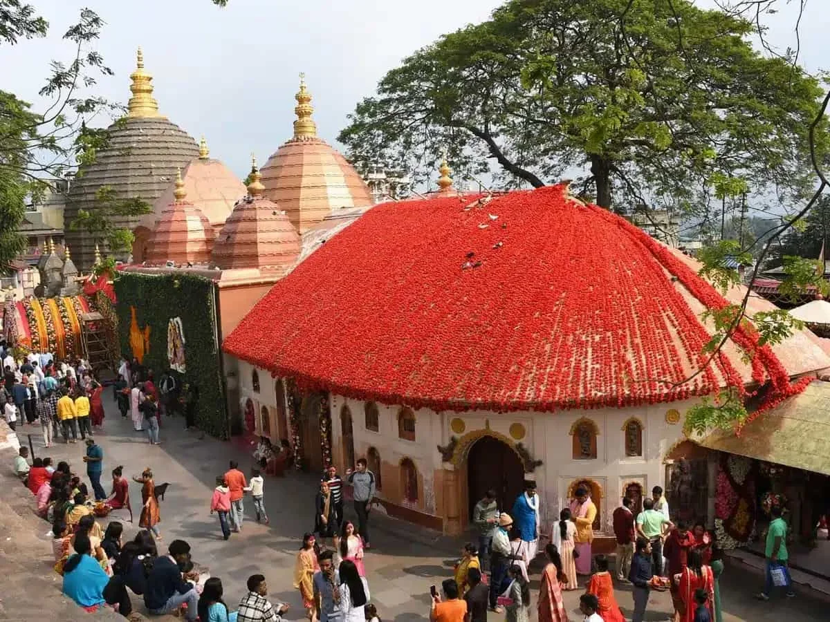 Sân đền Kamakhya với mái nhà đỏ, tháp vàng và đông người hành hương