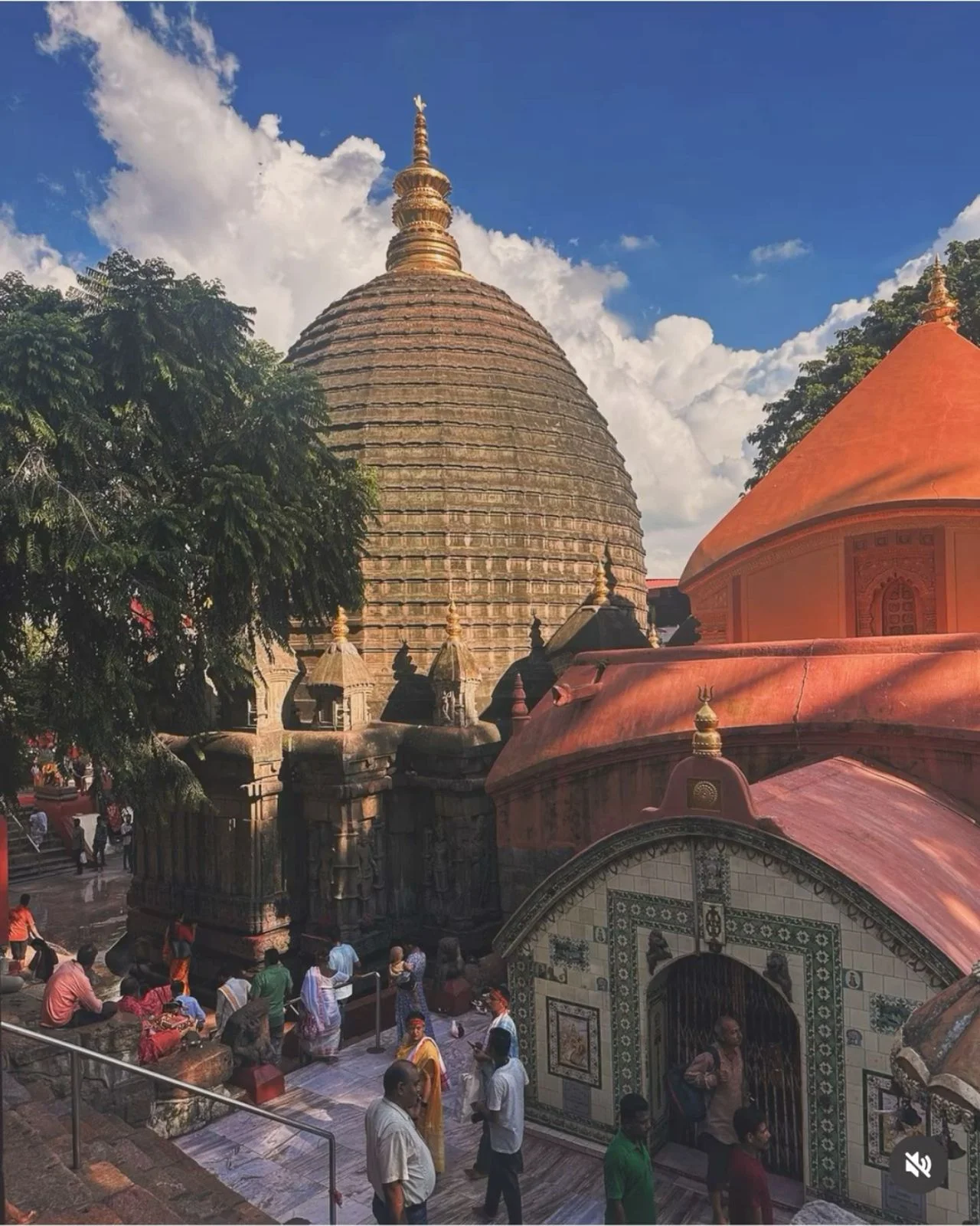 Đền Kamakhya dưới mây trắng với mái vòm lớn và dòng người tham quan