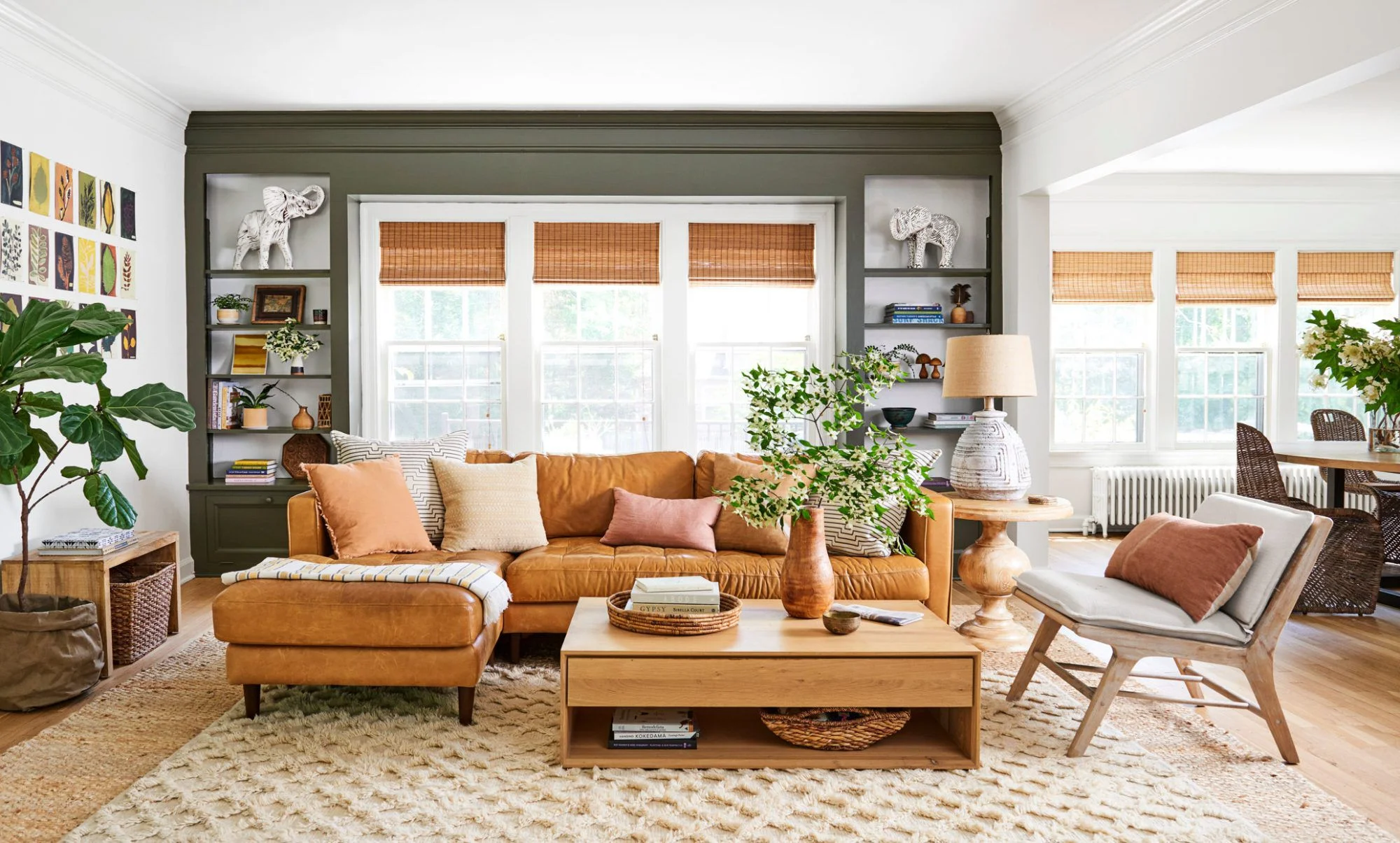 Hình nền đẹp cute với phòng khách ấm cúng, sofa da màu caramel, cây xanh và ánh sáng tự nhiên