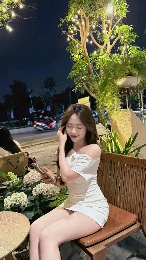 Gái xinh mặc váy trắng ngồi thư giãn buổi tối