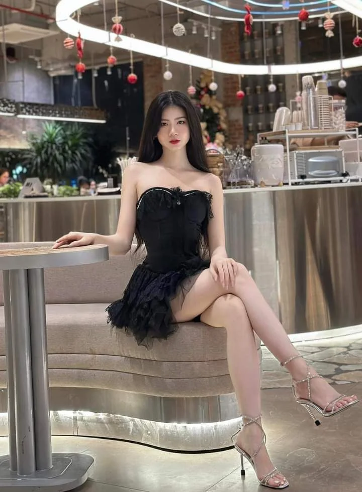 Gái xinh mặc váy cúp ngực đen ngồi tại quán cafe
